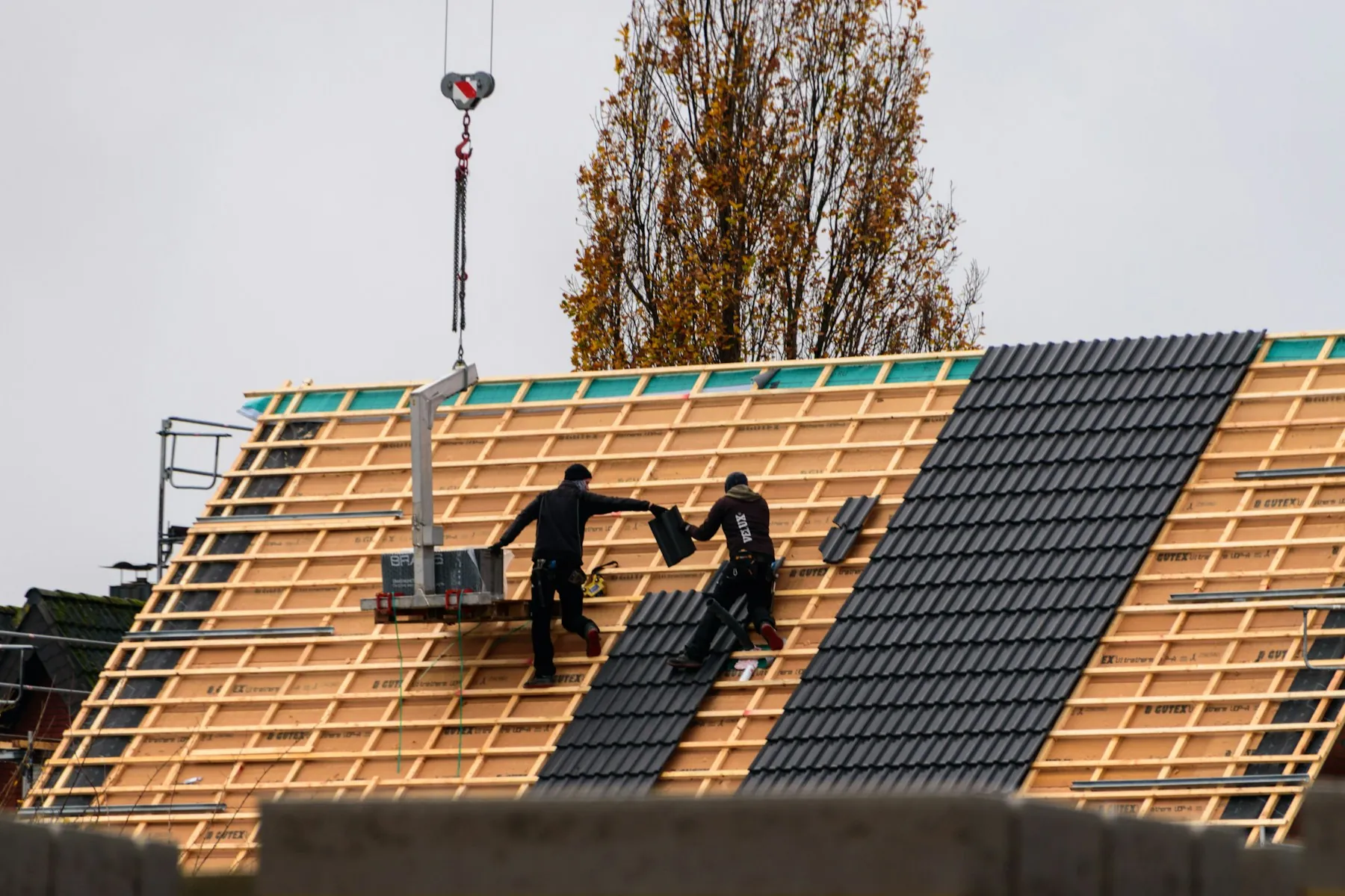 Dachdecker bei der präzisen Montage neuer Dachziegel